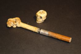A 19th Century carved ivory parasol handle as a lion entwined by a snake, attached to a wooden shaft