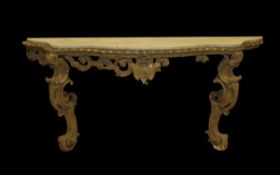 A George III carved giltwood framed console table, the later grey veined white marble top of