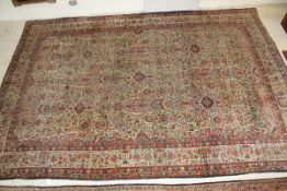 A Persian carpet, the central cream ground with all over floral decoration in red, blue and green,