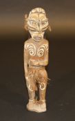 A Papua New Guinea standing ancestor figure with cowrie shell eyes and cowrie shell head dress,