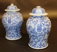 A pair of Chinese blue and white baluster shaped marriage vases and covers with all-over