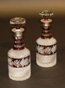 A pair of Bohemian pineapple cut and ruby flash overlaid glass decanters with silver necks, together