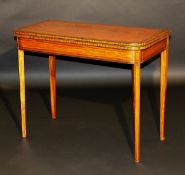 A Regency satinwood and inlaid foldover card table, the top cross banded opening to reveal a baize