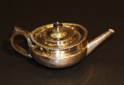 A George IV silver teapot of squashed oval form with applied gadrooned edge and ebonised handles (by