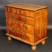 An 18th Century walnut chest, the quartered top with ivory parquetry work inlaid banding over two