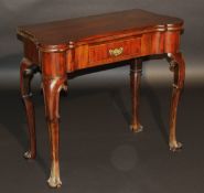 A mahogany foldover tea table in the early 18th Century taste, the shaped top over a single frieze
