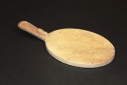 A Robert Thompson of Kilburn (The Mouseman) cheese board with plain handle decorated with mouse,