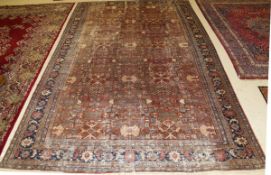 An Agra carpet, the central panel set with repeating stylised floral and geometric pattern on a rust