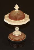 A 17th Century Indian sandalwood and ivory finial of fluted spherical form raised on an ebony