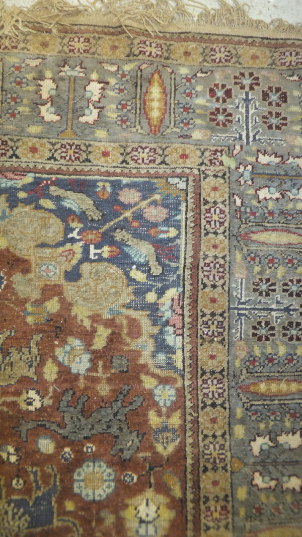 A Persian carpet, the central panel set with a floral decorated medallion on a brown ground with - Image 5 of 10
