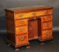 A 19th Century mahogany kneehole desk in the Chippendale taste, the plain top with applied moulded