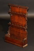 An 18th Century oak pipe rack, the blind fretwork decorated frieze over two six section racks and