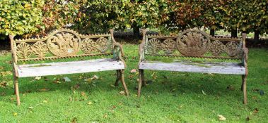 A pair of 19th Century painted cast iron garden benches decorated with medallions of floral sprays