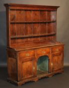 A circa 1800 oak dresser, the two tier boarded plate rack with moulded cornice and various cup hooks