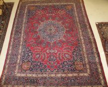 A Persian carpet, the central panel set with floral decorated medallion on a dark pink ground set