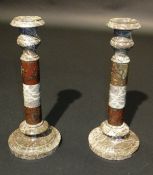 A pair of serpentine marble candlesticks, the baluster shaped tops to three section column raised on