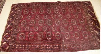 A Bokhara carpet, the central panel set with five rows of repeating elephant foot medallions on a