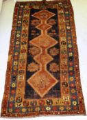 A Caucasian rug, the central panel set with five conjoined diamond medallions on a blue ground