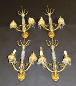 A set of four early 20th Century Venetian glass and gilt metal two branch wall light fittings, the