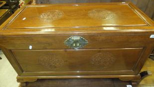 A Chinese teak camphor wood lined chest decorated with shoo symbols on ogee bracket feet