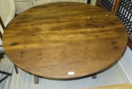 A 19th century French walnut circular kitchen table raised on trestle supports with triangular