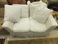 A modern two seat sofa, upholstered in off white fabric