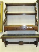 An early 20th Century mahogany three tier wall shelf with carved side panels and two drawers and