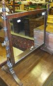 A late 19th Century mahogany dressing mirror, the rectangular plate supported by turned stand