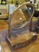 A 19th Century toilet mirror, the oval plate above a serpentine base with three drawers