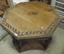 An oak octagonal two tier centre table with carving to the top and to the frieze with carved and