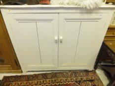 A white painted linen press cupboard on simple supports
