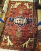 A Hamadan rug, the central star shaped medallion in dark blue, cream and taupe on a red geometric