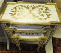 A nest of three cream and gilt decorated occasional tables