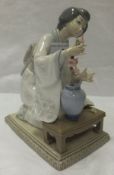 A Lladro porcelain figure of a geisha with vase of flowers, No'd. J-13 to base   CONDITION