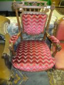 A late 19th / early 20th Century salon elbow chair with acanthus decoration, upholstered in burgundy