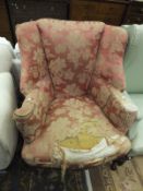 A circa 1900 wing back scroll arm chair in the early 18th Century taste, upholstered in pale red