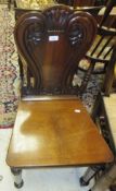 A mahogany panel seated hall chair with scrolled carving to back