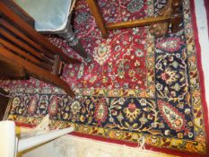 A Persian carpet, the red centre field with all-over floral decoration in pale blue, cream and