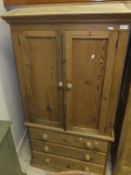 A pine two door cupboard over a chest of three drawers