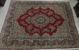 A Persian carpet, the central floral decorated medallion in cream, pale blue, red and dark blue on a