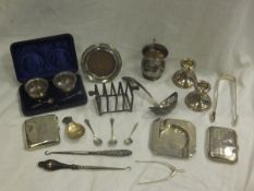 A collection of silver wares to include a pair of weighted silver candlesticks, a pair of cased