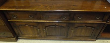 A modern oak dresser in the 18th Century manner with three drawers over two panelled cupboard doors