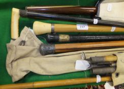 A pool cue, selection of walking sticks and two fishing rods