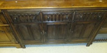 An oak dresser, the three drawers with linenfold decoration above three cupboard doors on stile