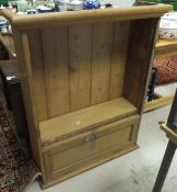A pine bookcase with fall flap cupboard below