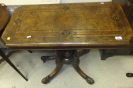 A Victorian walnut and inlaid fold-over card table on quadruped base