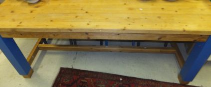 A modern pine kitchen table with blue painted legs united by stretchers and matched set of four