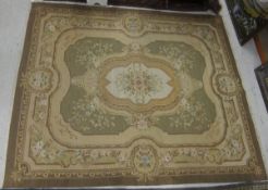 An Aubusson style carpet, the central floral decorated medallion on a cream ground within salmon and