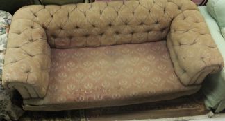 A Victorian buttoned upholstered Chesterfield sofa on turned legs to brass caps and castors