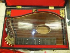 A guitar zither, un-named, in carrying case